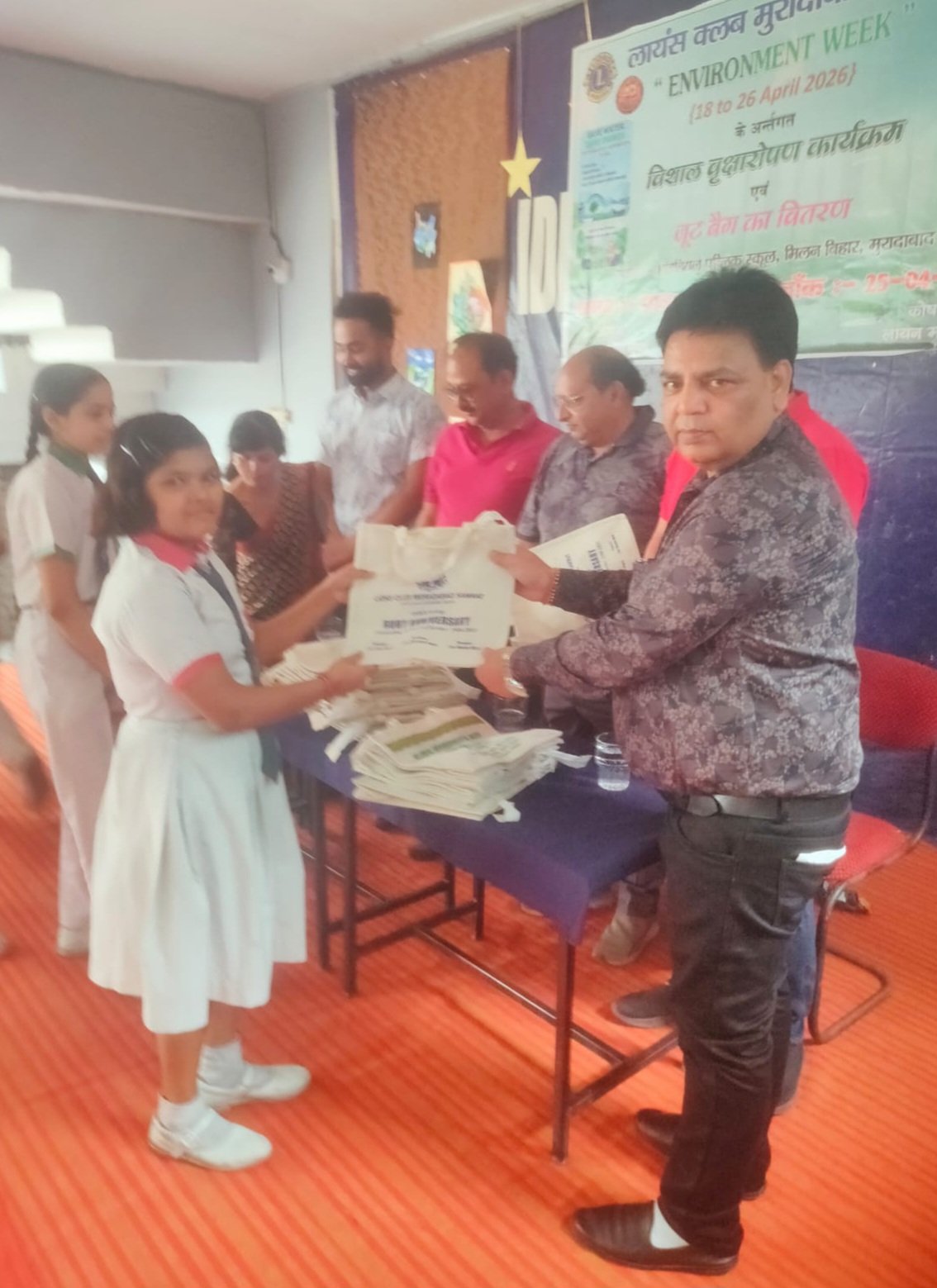 जूट बैग वितरण करते लायंस क्लब सदस्य