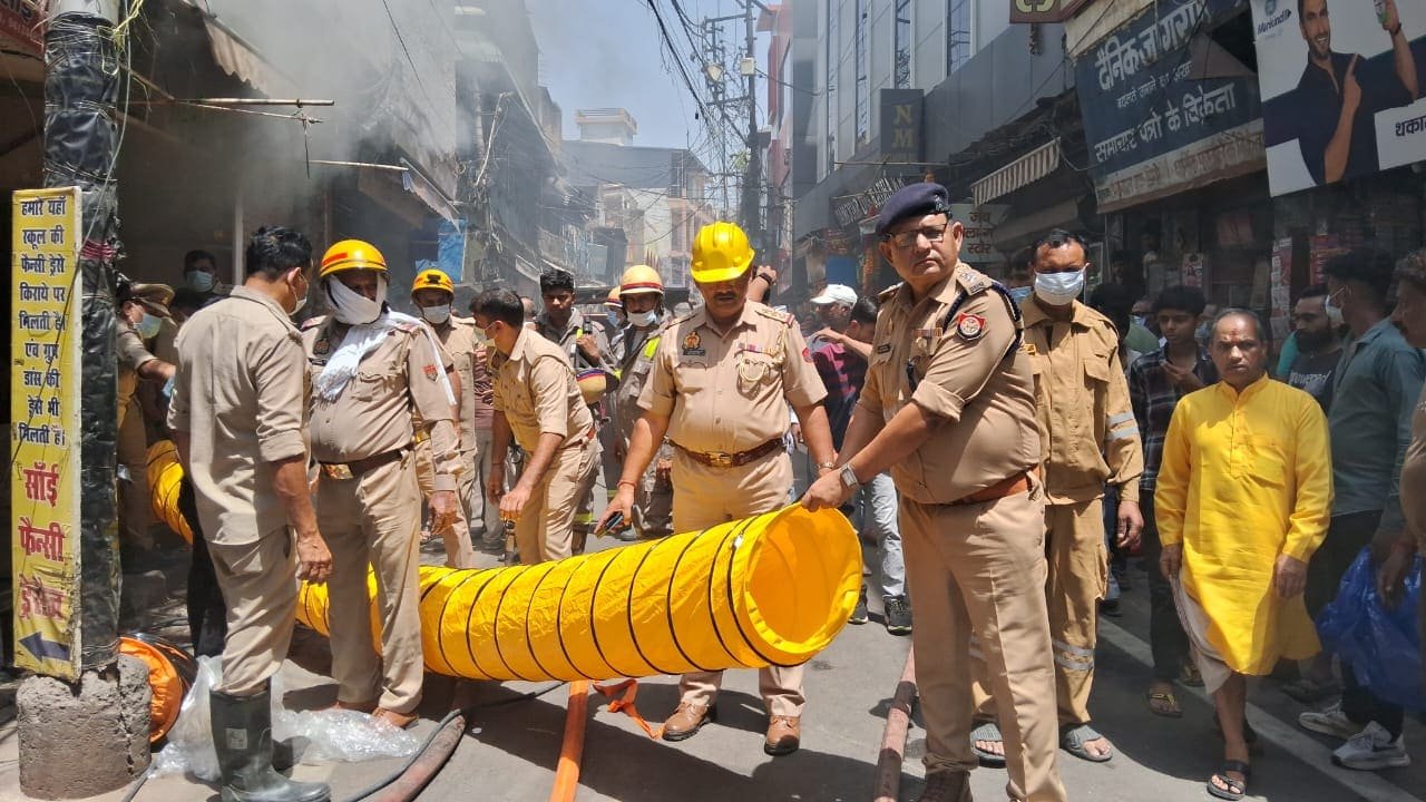 मुरादाबाद के बर्तन बाजार में बेसमेंट की दुकान में लगी भीषण आग के दौरान मौके पर आग बुझाती दमकल विभाग की टीम