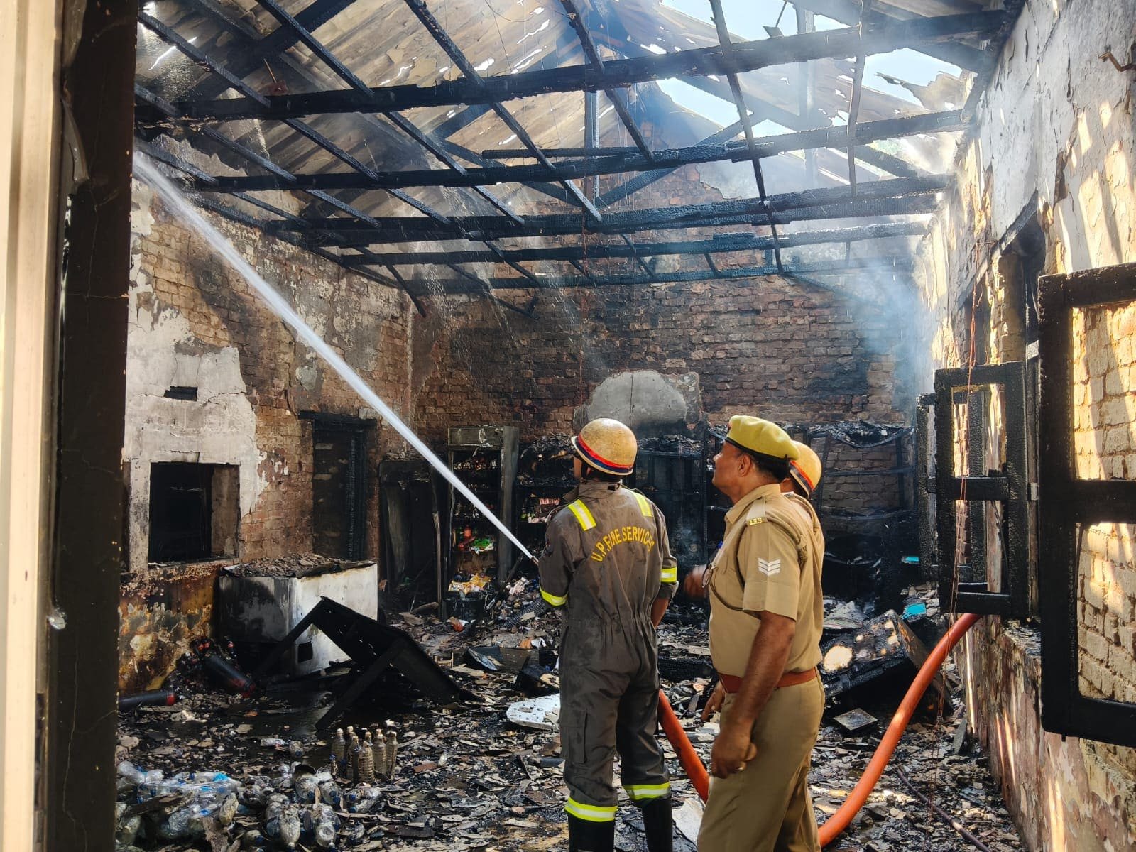 मुरादाबाद की 24वीं वाहिनी पीएसी परिसर की कैंटीन में लगी भीषण आग के बाद मौके पर आग बुझाते दमकल कर्मी।