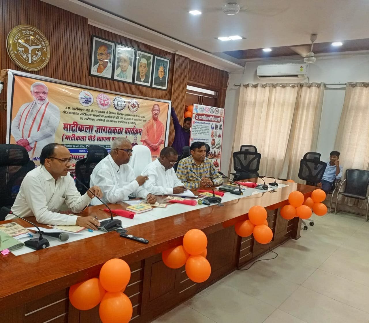 मुरादाबाद कलेक्ट्रेट सभागार में माटीकला बोर्ड स्थापना पखवाड़ा के तहत आयोजित जनपद स्तरीय जागरूकता कार्यक्रम में उपस्थित मुख्य अतिथि, अधिकारी और माटीकला कारीगर।